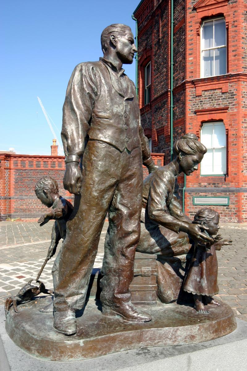 statue of a family preparing to board a ship