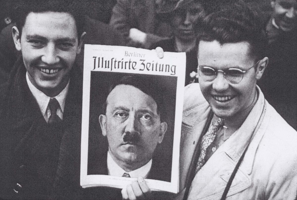 Elder Cannon and Brother Alden with a picture of Adolf Hitler