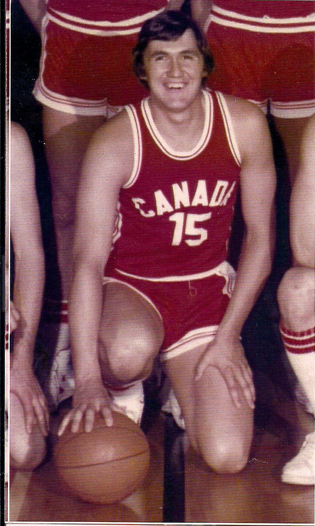 Phil Tollestrup kneeling with a basketball