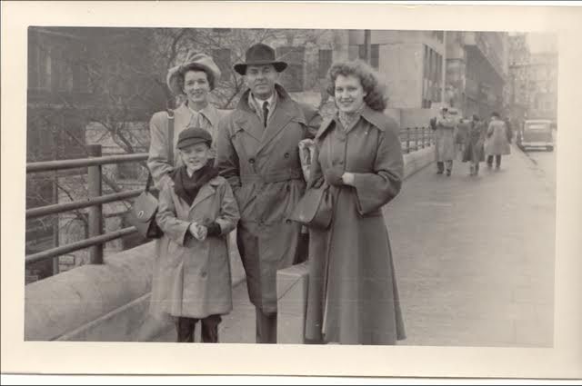 family of four standing near a bridge