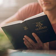 A person reading from the Book of Mormon, showing the cover