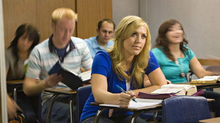 Students in a classroom listening to the teacher