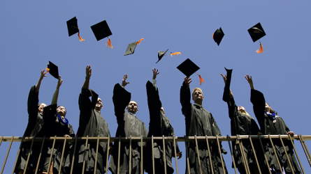 A group of graduates tossing their caps into the air