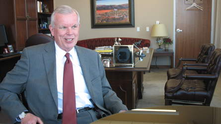 Elder Steven E. Snow sitting behind a desk, smiling
