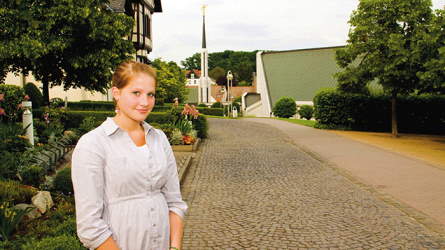 A young woman standing by a street with the temple in the background