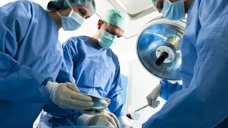 Surgical staff surrounding a patient being operated on