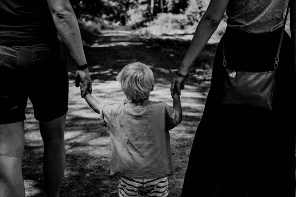 image of a little boy holding his parents' hands