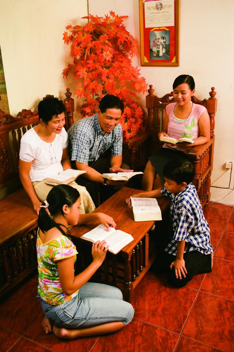 A family studying the scriptures for family home evening