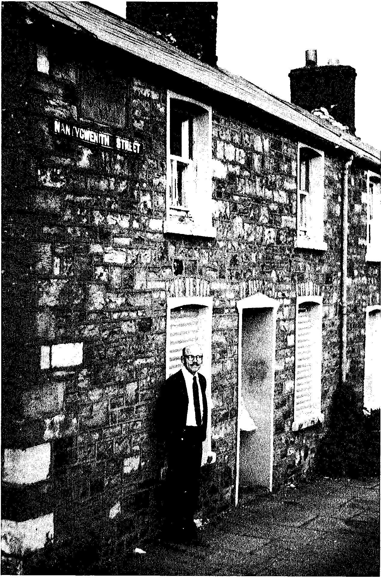 MAN STANDING IN FRONT OF A HOUSE
