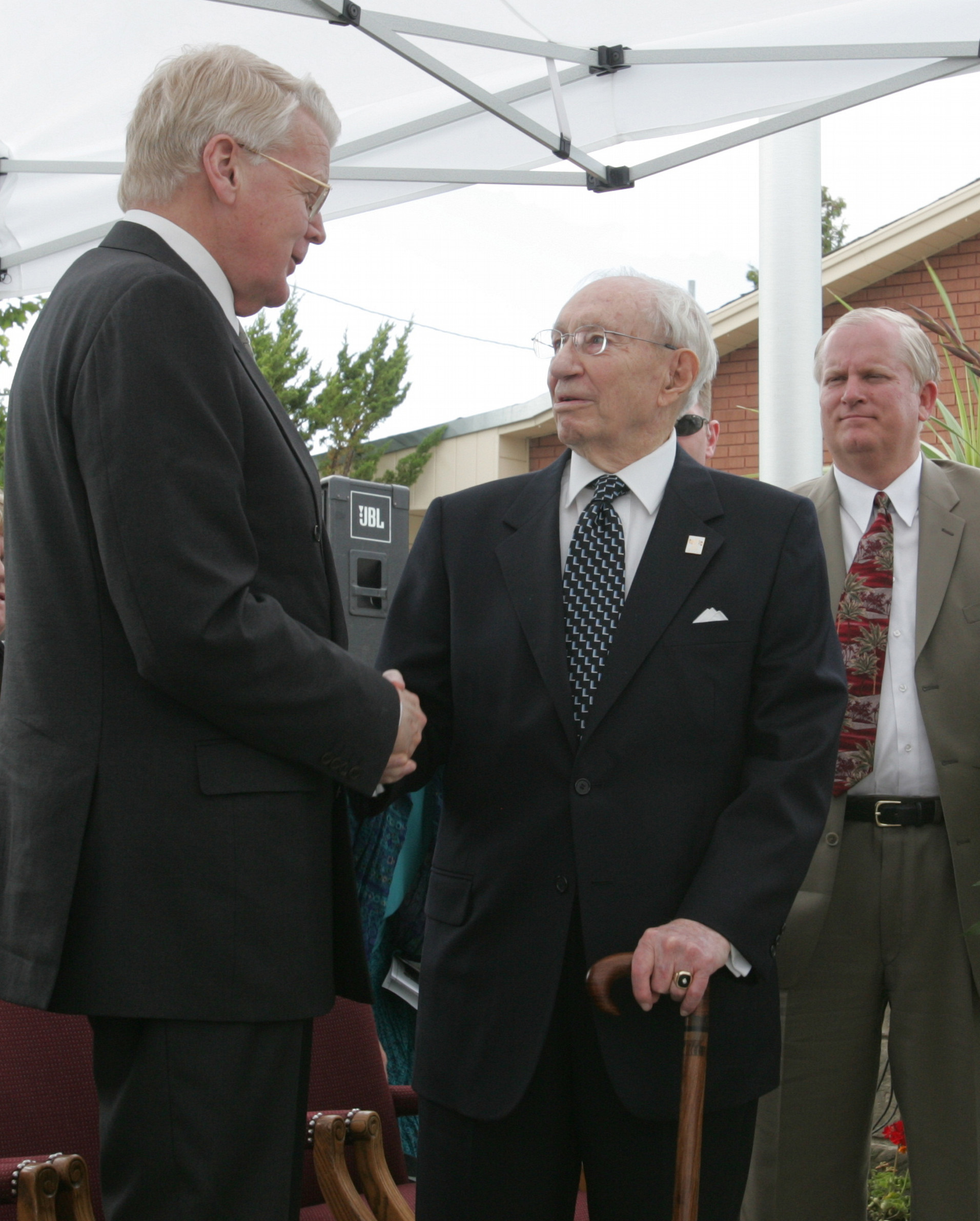 Michael L. Hutchings, secretary of the Mormon Historic Sites Foundation, looks on as Ólafur Ragnar Grímsson, president of Iceland, and Gordon B. Hinckley, president of The Church of Jesus Christ of Latter-day Saints, shake hands. Courtesy of Deseret Morning News