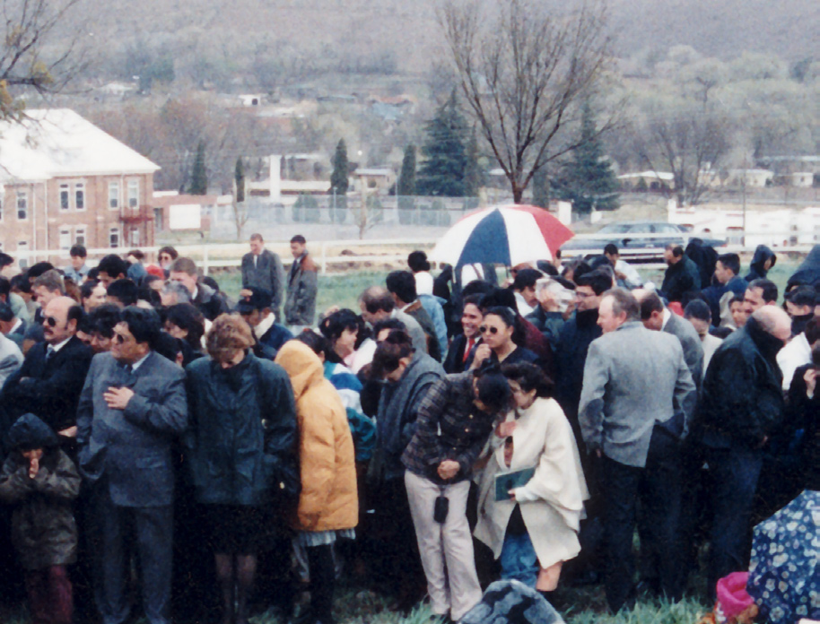 Crowds gathered in stormy weather (left) for the groundbreaking, but the sun broke through (right) as President Eran Call was about to offer the prayer dedicating the site.