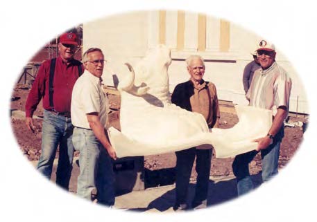 Left to right: Howard Schmidt, Elder Richard Skidmore, Jasper McClellan, and Ron Dalene carrying one of the oxen for the baptismal font.