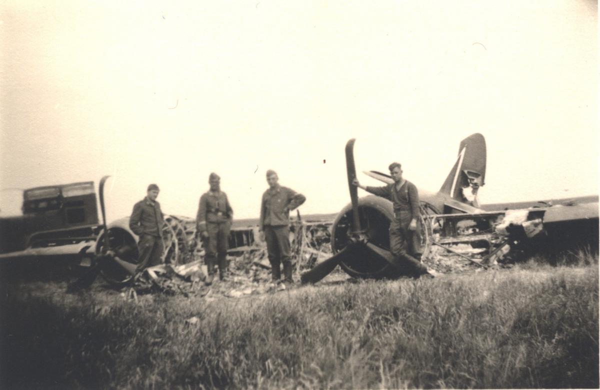 German soldiers inspect the ruins of a French plane downed by antiaircraft fire.