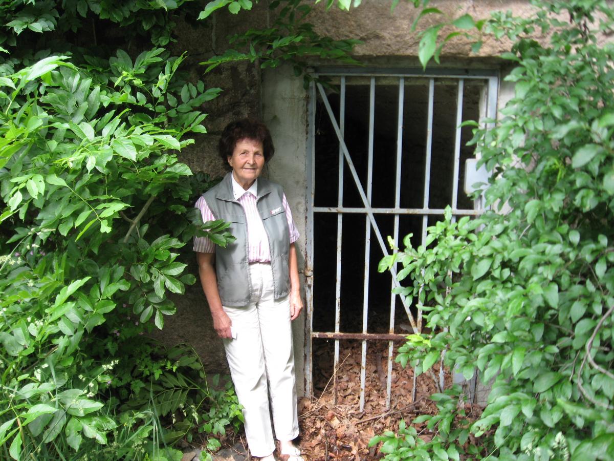 Irene Härtel Schönfeld stands at the entrance to the small cave