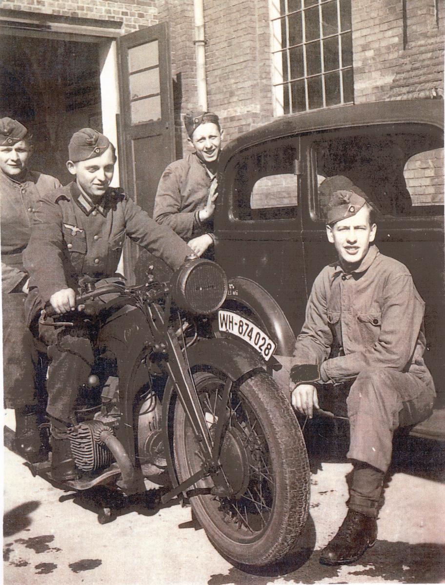 Walter Kindt with others outside with car and motocycle
