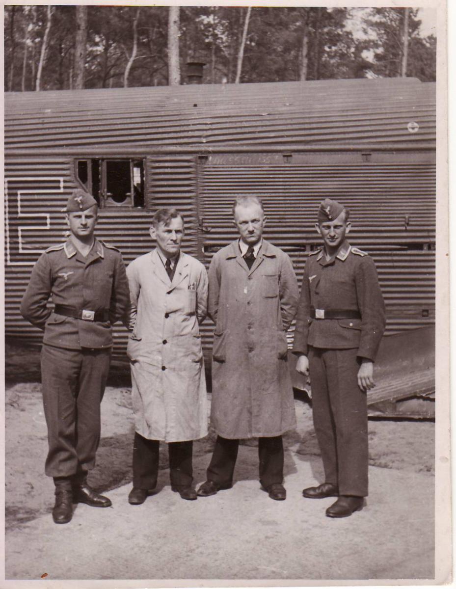 four men in front of factory