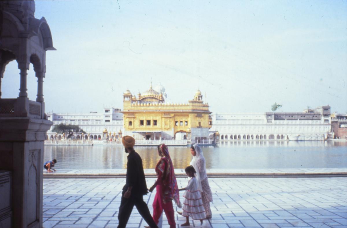 A Sikh family walks past the Golden Temple at Amritsar, India.