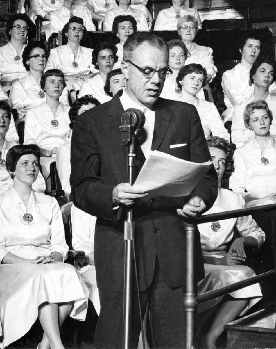 Richard L. Evans standing in front of the Tabernacle Choir during a broadcast of Music and the Spoken Word