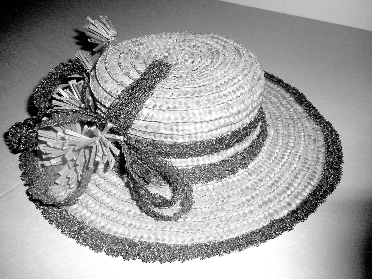 A typical ladies leghorn-style hat—referred to as a straw boater; made by Mary Jorgensen Seely in the early 1900s. Note the trim. This bonnet features nine straw flowers and is trimmed with braided horse hair. LDS 84–124–9–2 Church History Museum.