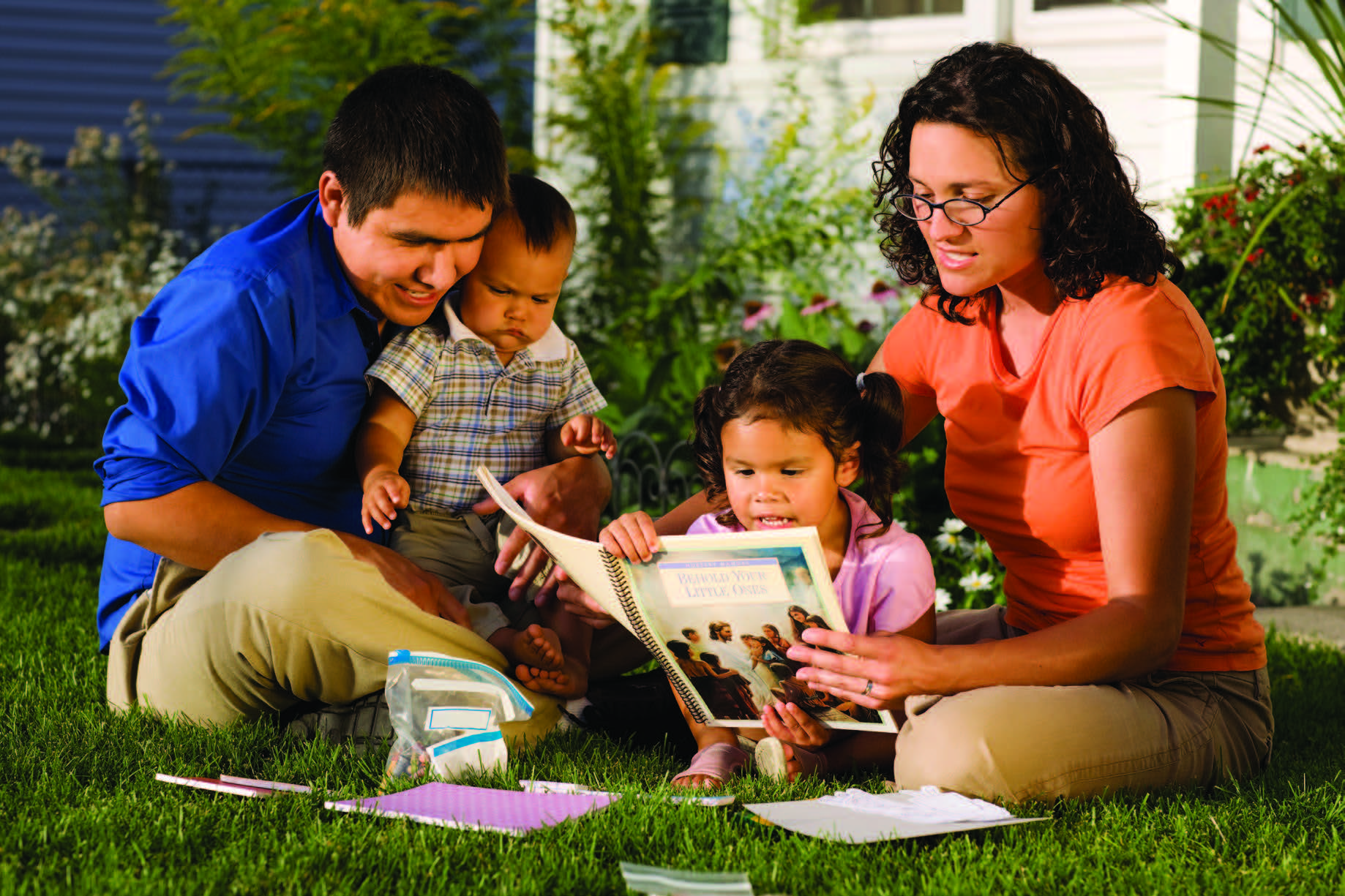 a small family reading books in the yard