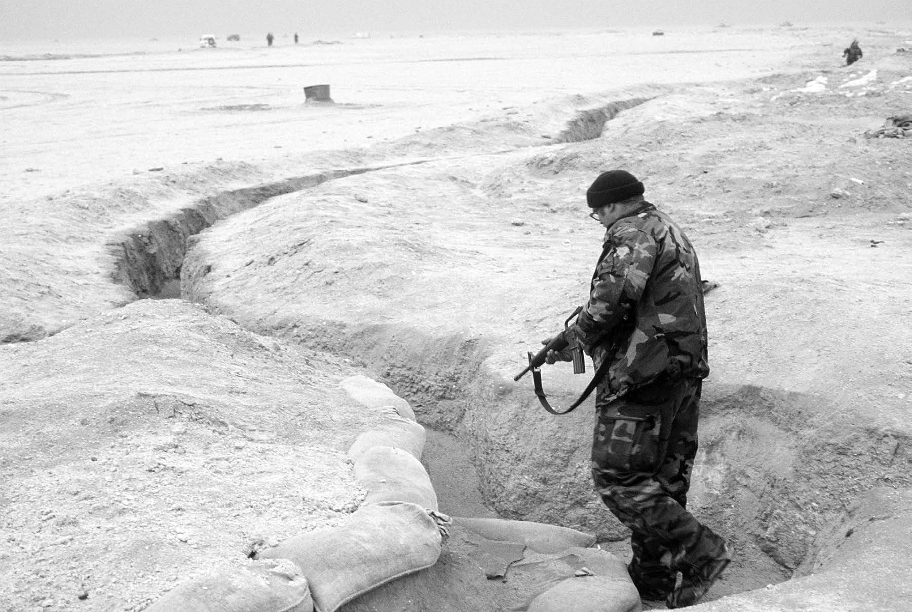 A coalition special forces soldier inspects an Iraqi trench for enemy soldiers during Operation Desert Storm. Courtesy of DoD.