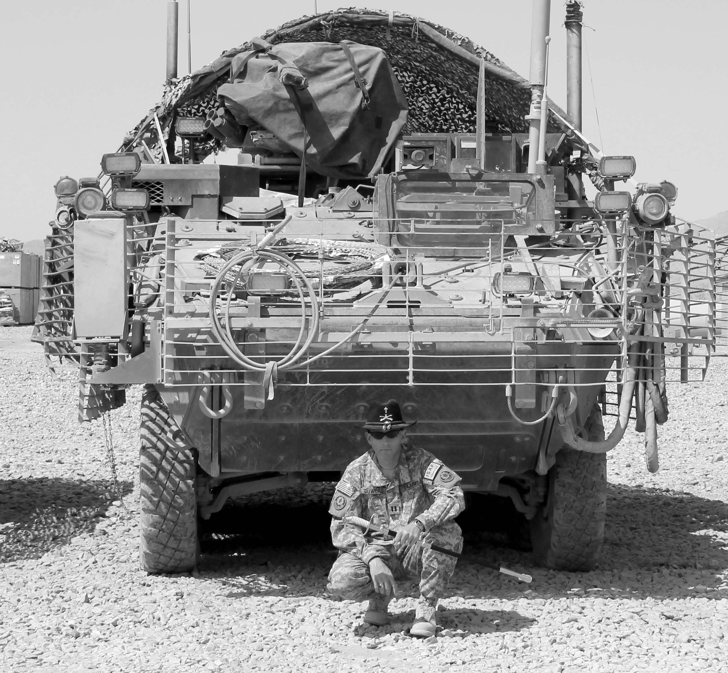Latter-day Saint chaplain J. Joseph DuWors posing with a saber in front of a loaded Stryker vehicle. Courtesy of J. Joseph DuWors.
