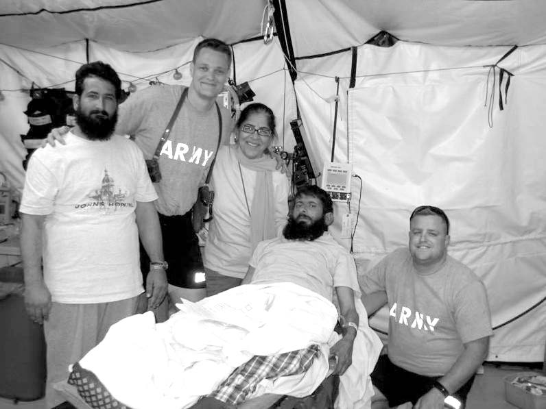 A hospital scene showing Dr. Neil McMullen (second from left), his surgery partner (on the right), a translator (center), a patient, and his brother. Courtesy of Neil McMullen.