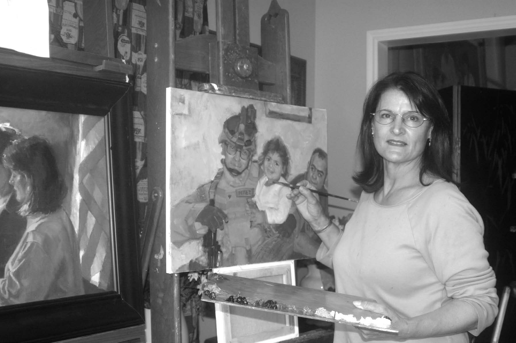 Anne Marie Oborn standing by one of her paintings of a fallen soldier. Courtesy of Anne Marie Oborn.