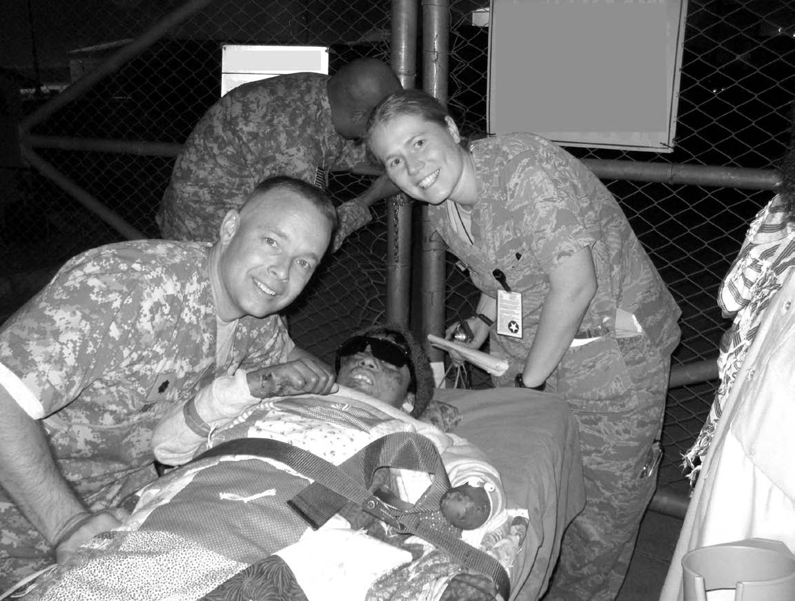 Hamed Hilal, an Afghan boy who received significant injuries from a bomb or IED blast, is pictured being loaded on a helicopter for his flight home in October 2010. The photo shows Lieutenant Colonel Blaine Tuft, Hamed, and his nurse, Lieutenant Nita. Courtesy of Blaine Tuft.