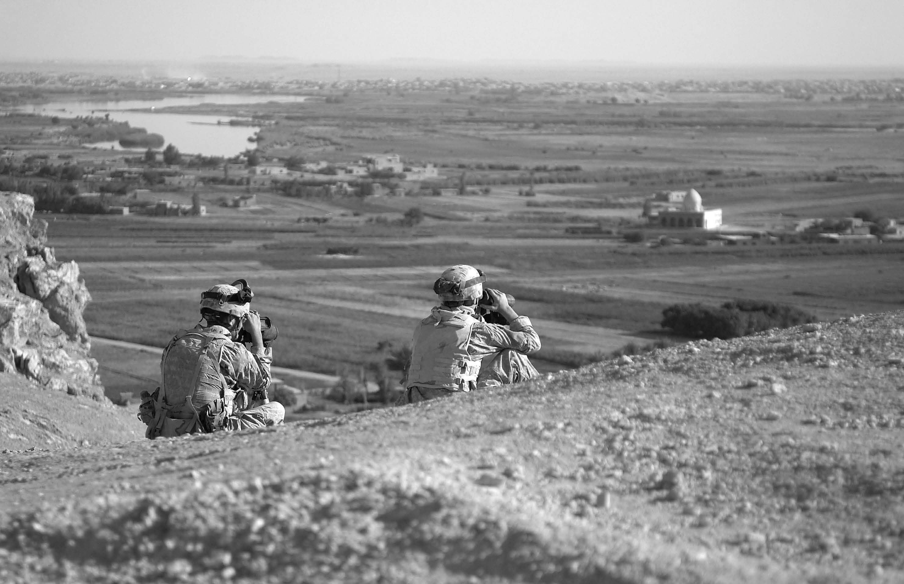 U.S. Army soldiers with the 14th Cavalry Regiment from Fort Wainwright, Alaska, near the Syrian border monitor the movement of local Iraqis by the Euphrates River in Iraq on October 2, 2005. Courtesy of DoD.