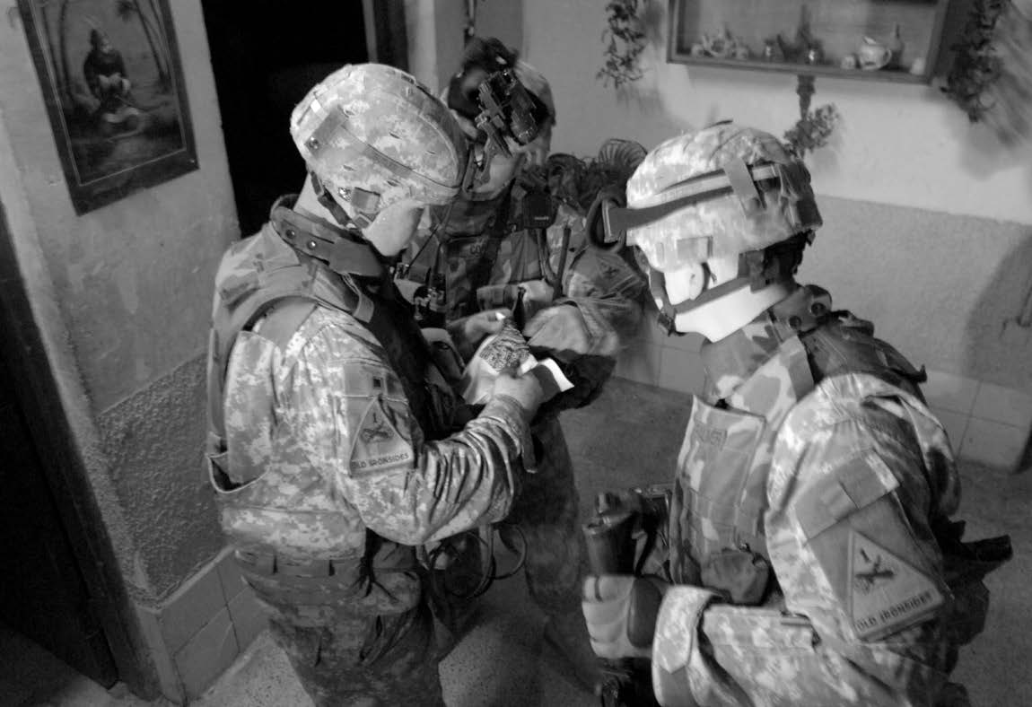 U.S. Army soldiers examine a map found by fellow soldiers during a house search in Al Bayaa, Iraq, June 21, 2006. Courtesy of DoD.