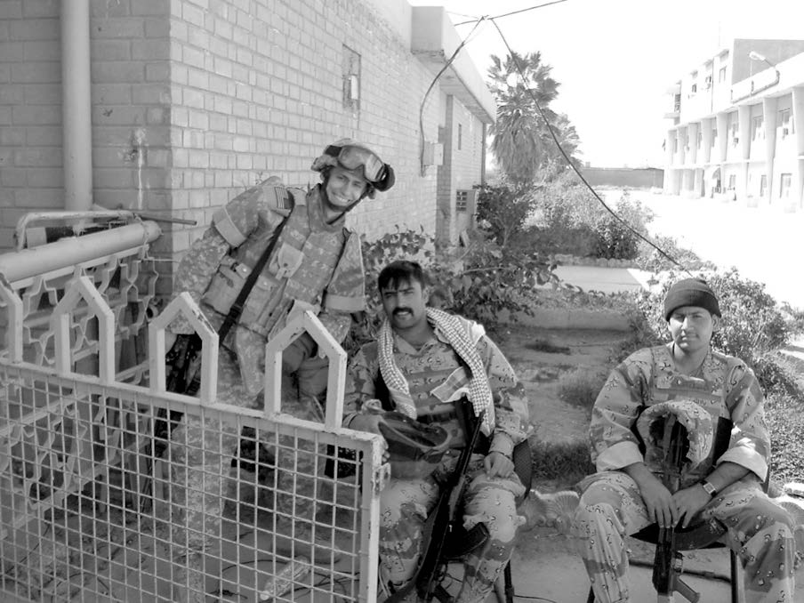John Cox (standing) with two Iraqi soldiers. Courtesy of John Cox.