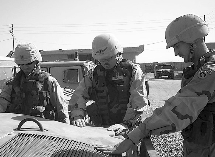 Chaplain Christopher Degn is shown praying over a Humvee he was asked to bless before it “left the wire.” Courtesy of Christopher Degn.