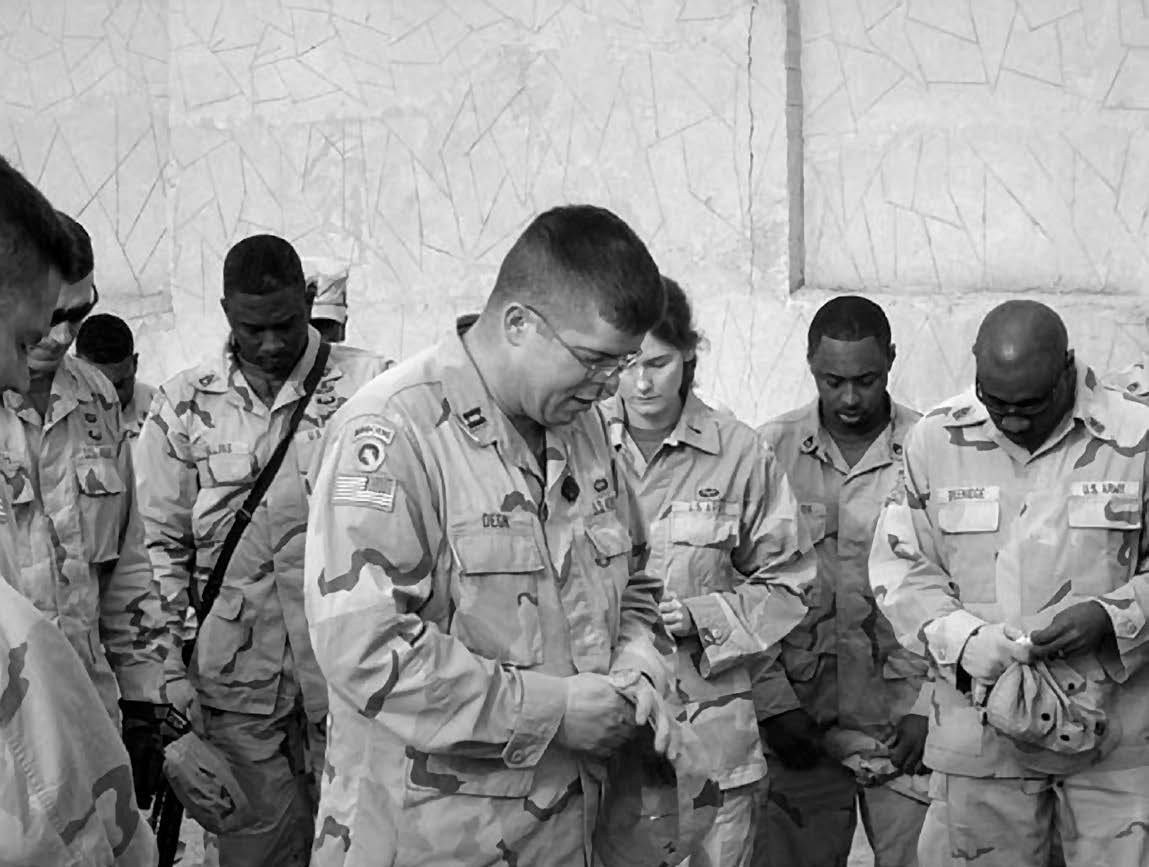 Chaplain Christopher Degn is pictured leading a group of soldiers in prayer in Iraq. Courtesy of Christopher Degn.