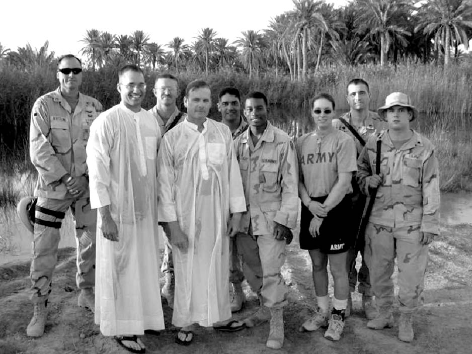 The 3rd Armored Cavalry Regiment’s Latter-day Saint service member’s group is shown after performing a baptism for Sergeant Kevin Wood (center) in an oasis in western Iraq’s Al Anbar province. Staff Sergeant Tony Bertolino (far left) was later killed by sniper fire during a convoy traveling toward the Syrian border. Courtesy of Steve Gundry.