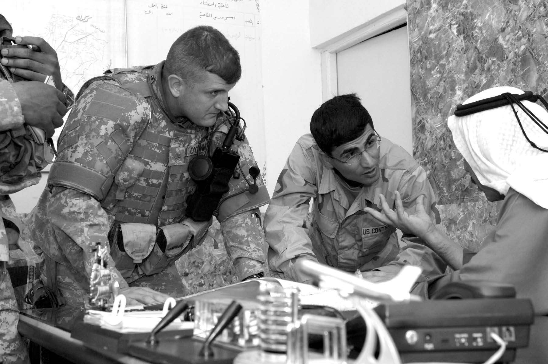 With the assistance of an interpreter, Sheik Luis Fandi Muhammed Salih Al-Obeidi, the mayor of Rashad, Iraq, discusses projects and locations of interest for clean-up efforts with the local U.S. Army commander from the 17th Cavalry Regiment. Courtesy of DoD.