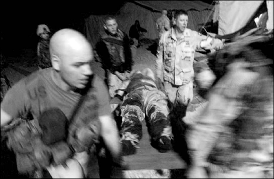 Captain Andras Marton (center), one of the officers in Colonel Richard Hatch’s unit, was wounded by shrapnel during a grenade attack and is shown being evacuated shortly after the nighttime attack. This photograph was taken by an embedded civilian reporter. Courtesy of Richard O. Hatch.