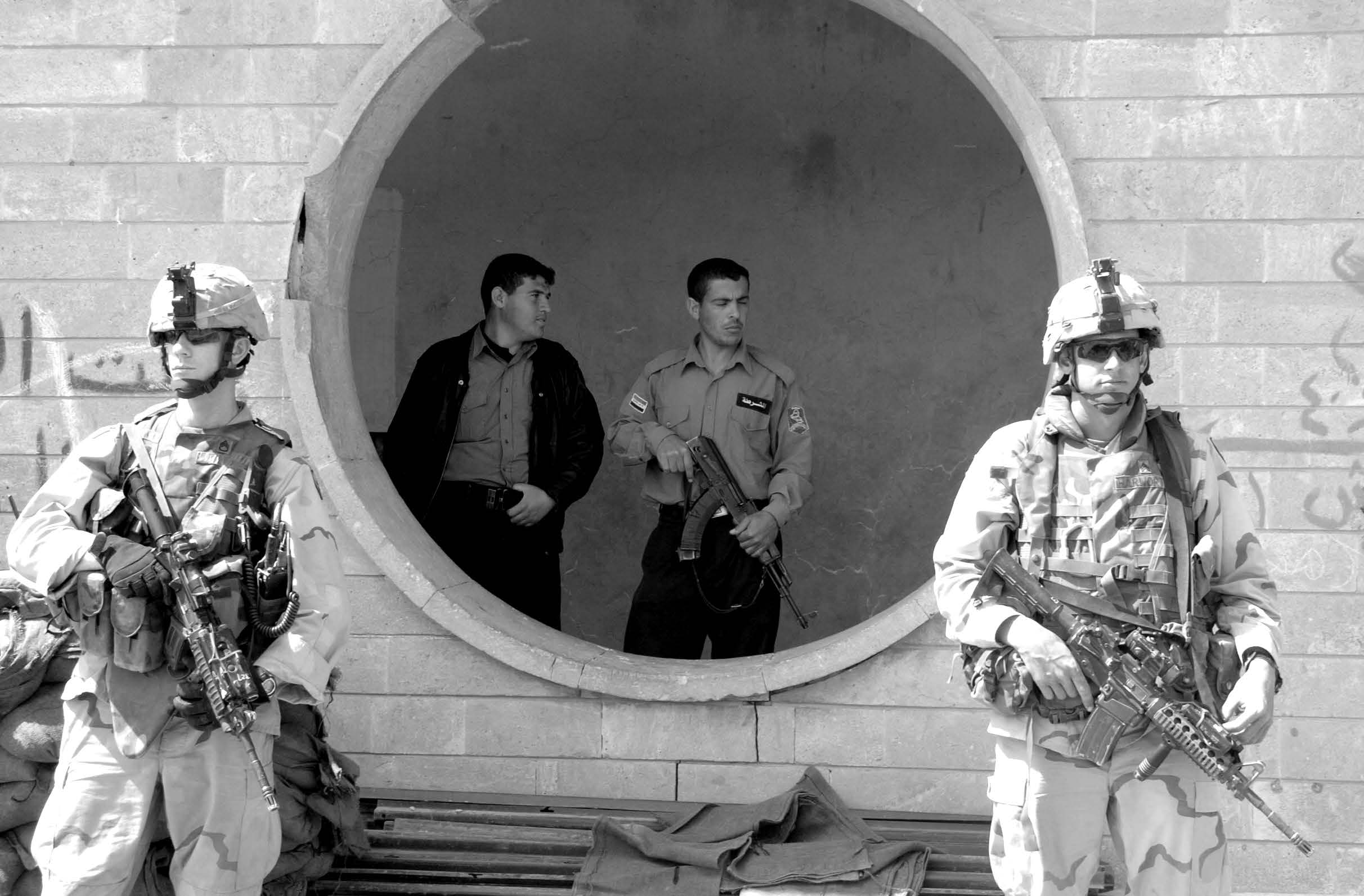 The two soldiers (in front) are armed with M4 rifles, and Iraqi police (in back) are armed with Tabuk 7.62mm short assault rifles. Courtesy of DoD.