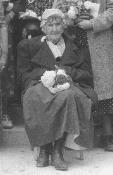 Margaret Baird sitting with flowers.