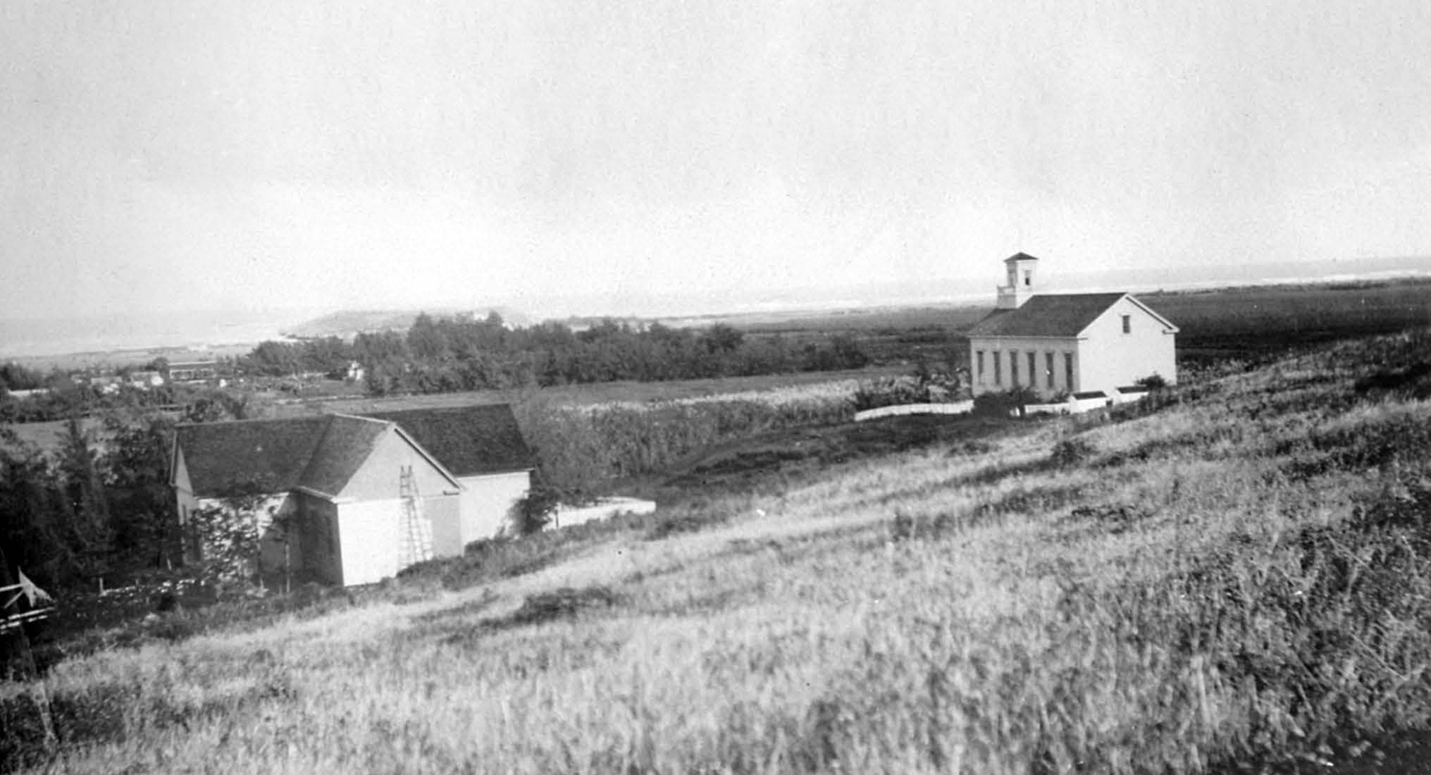The dedicated temple site where the chapel then stood is on a small hill gently sloping to the east overlooking the community of Lāʻie and the ocean beyond. Courtesy of Church History Library.
