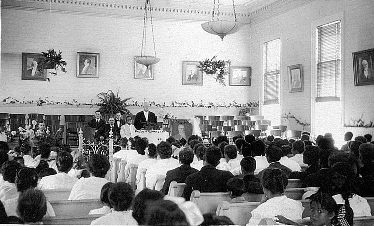 Completion of the Hawaii Temple occurred in the final throes of World War I, the rise of the Spanish flu pandemic, and the ailing health and eventual passing of President Joseph F. Smith. Right and below: Memorial service for President Smith, Lāʻie Chapel, with President Samuel E. Woolley at pulpit. Courtesy of Church History Library. Above images courtesy of Wikimedia Commons.