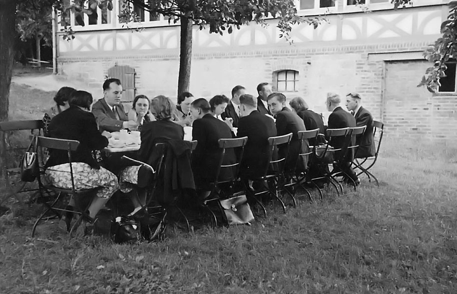 many people sitting at a table outside