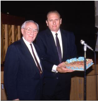 two men holding a cake
