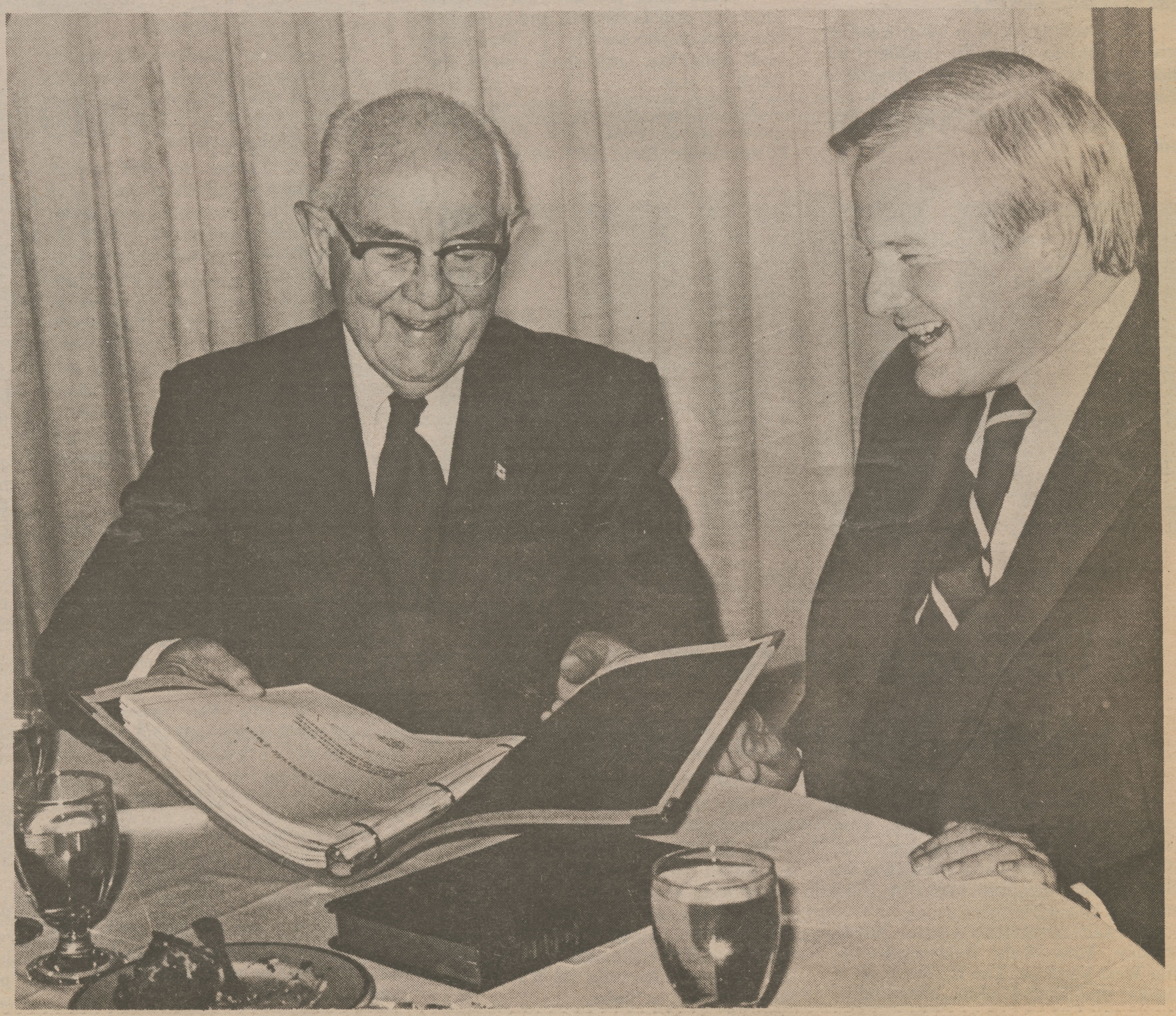 two men looking at a book together