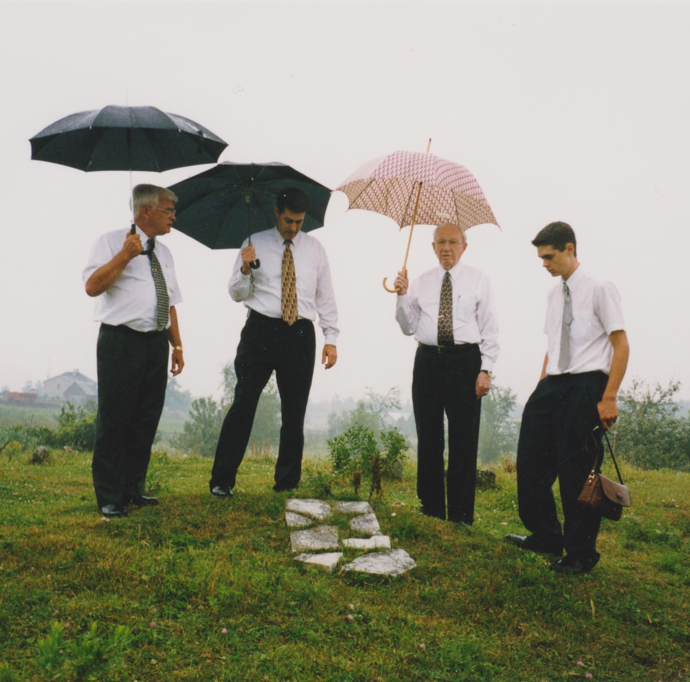 four people holding umbrellas