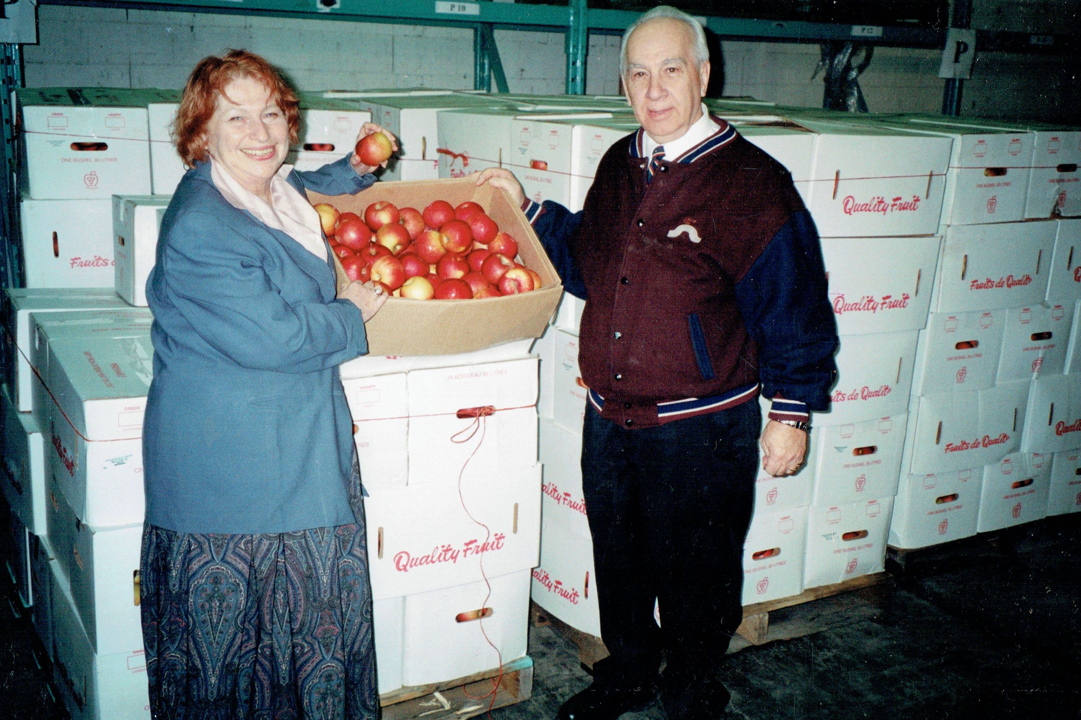 two people bringing apples to the bishop's storehouse