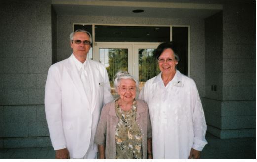 three people dressed in white outside the temple