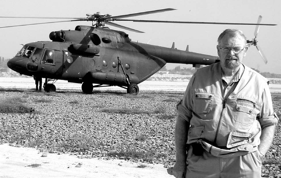 Richard Belcher pictured with an Afghan MI-17 helicopter, which he requested due to the danger of insurgent attacks when traveling overland. Courtesy of Richard Belcher.