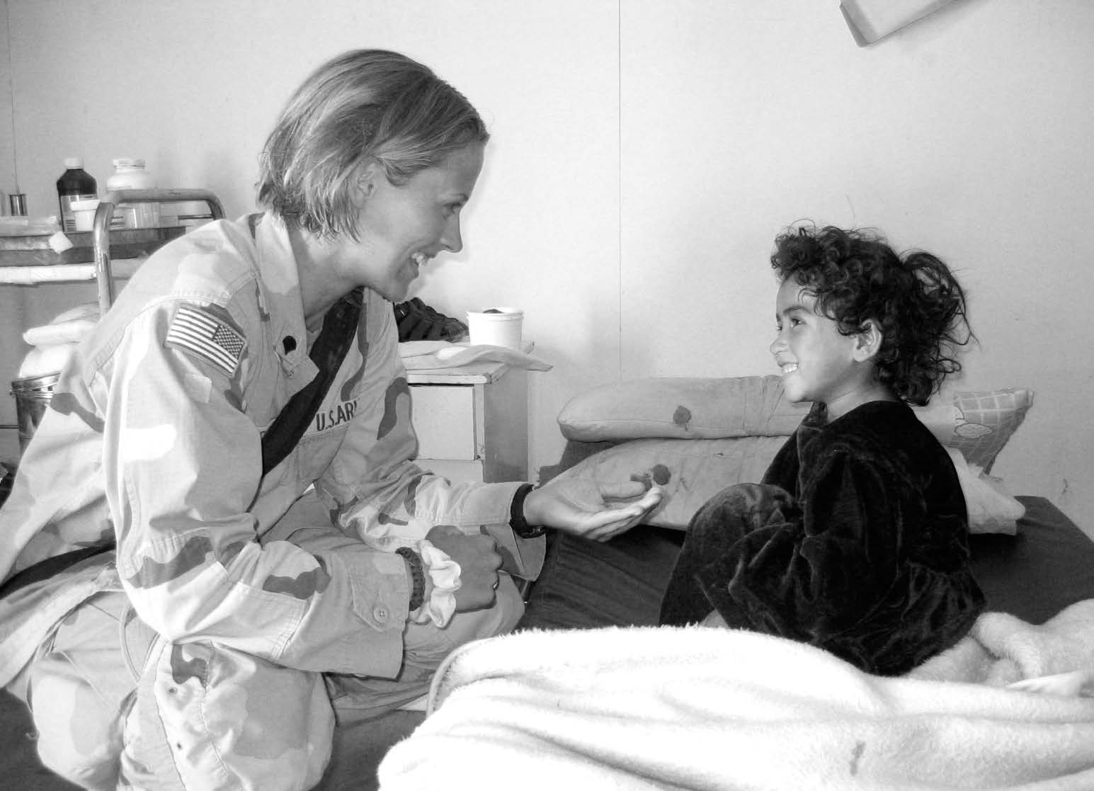 Specialist Jill Stevens comforting an Afghan child. Courtesy of Jill Stevens.