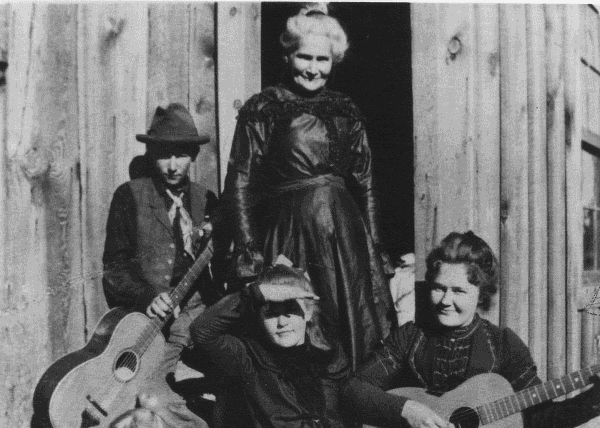 Mary Hansen with grandchildren holding guitars.